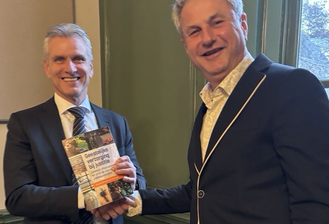 Hoofdpredikant Anne overhandigt het derde exemplaar aan Wim Saris.